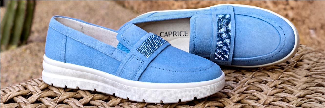 Mules bleues ornées de strass et semelles blanches sur tapis de raphia tressé