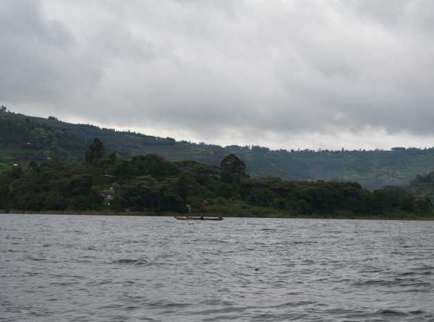Tourists peacefully boating through the charming lake bunyoni and viewing the Uganda mountains