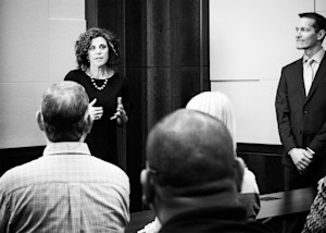 Abby Havermann at the front of a room speaking to a group of people.