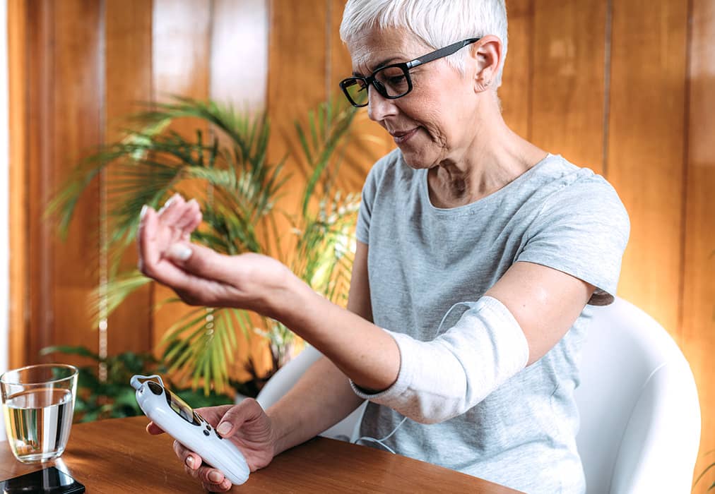 TENS nerve pain monitor being used by a senior woman