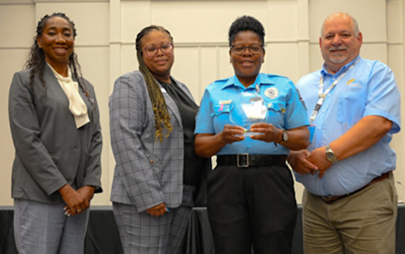 MCO Connections group photo of Avis Lewis receiving her safety award.