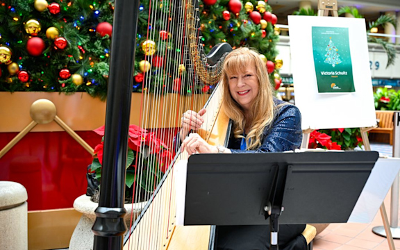 MCO Cares January 2026 Entertainment. Woman playing a harp in Terminal AB.