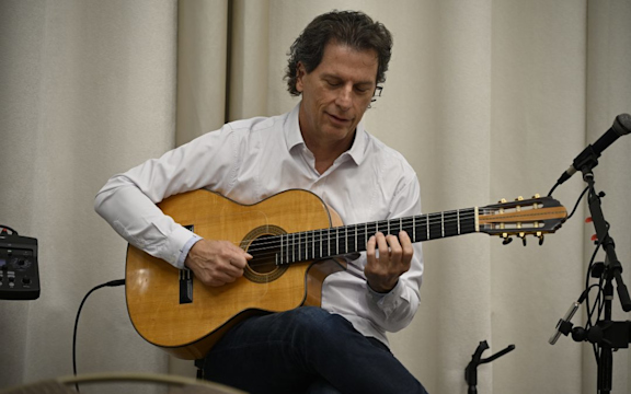 MCO Cares December 2025 Entertainment. Man playing a guitar.