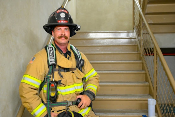 MCO Connections photo of firefighter standing on stairs.