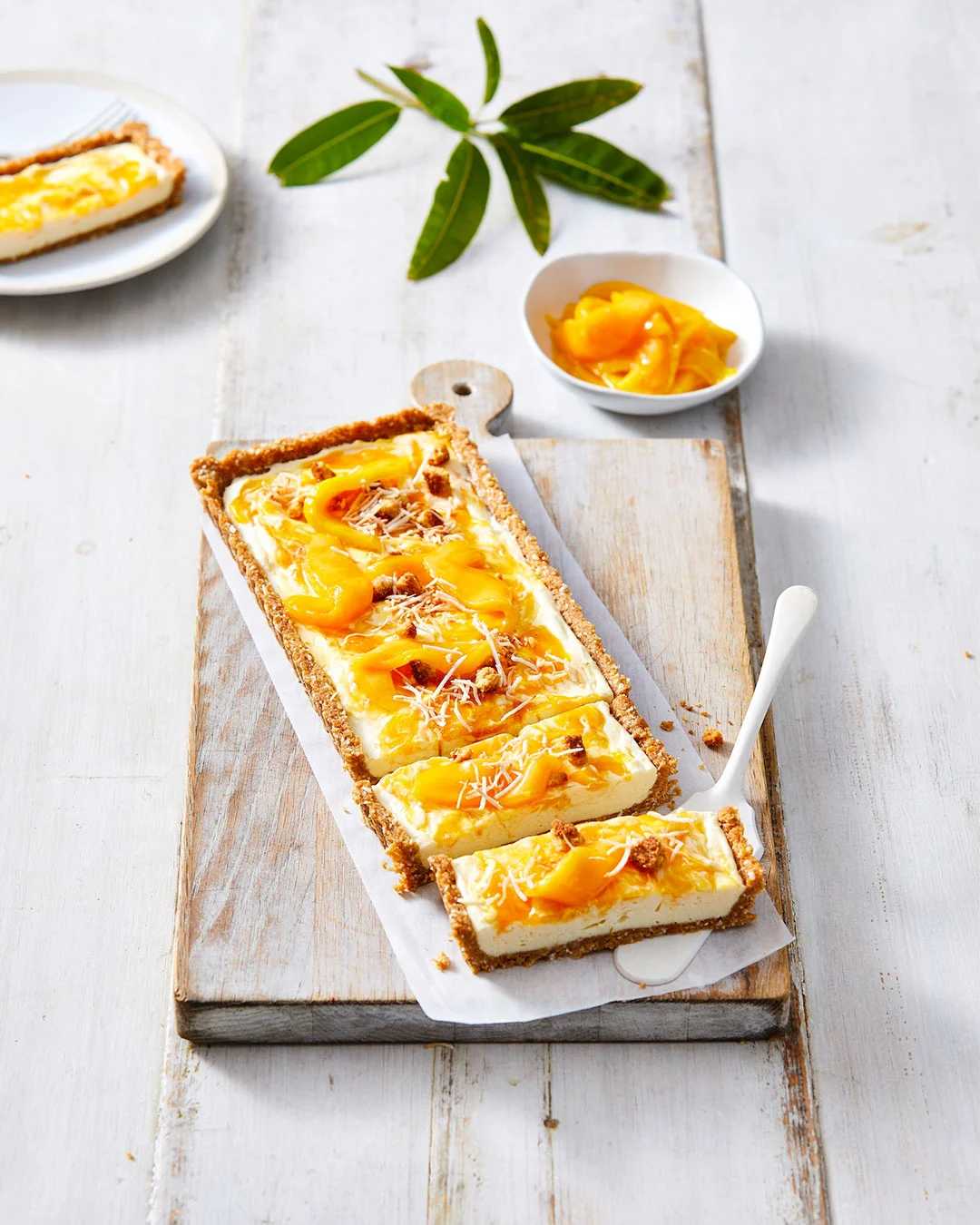 Image of Butternut Snap Mango Cheesecake, accompanied with fresh chopped mango. 