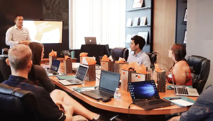 A group of marketers sat at a conference table watching a presentation