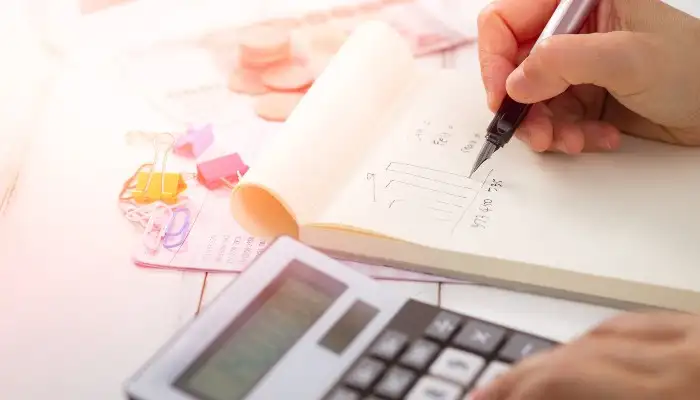 person doing calculations and writing notes