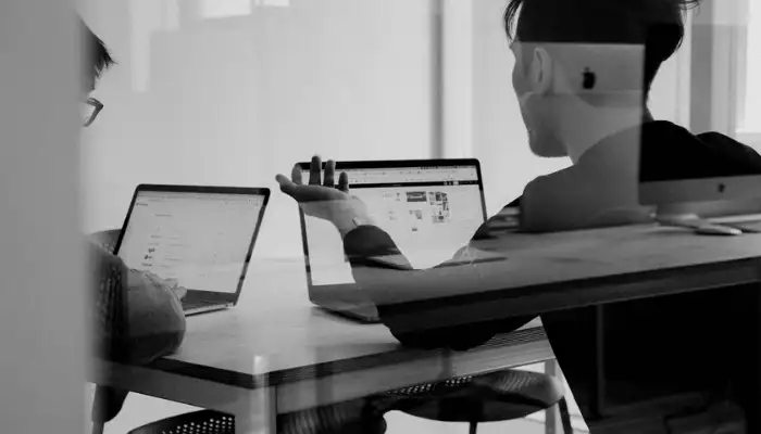 Two employees talking about raising funds in an office