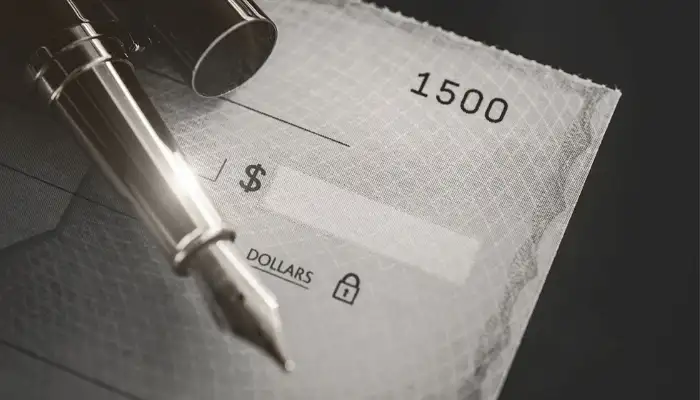 a blank cheque with uncapped fountain pen