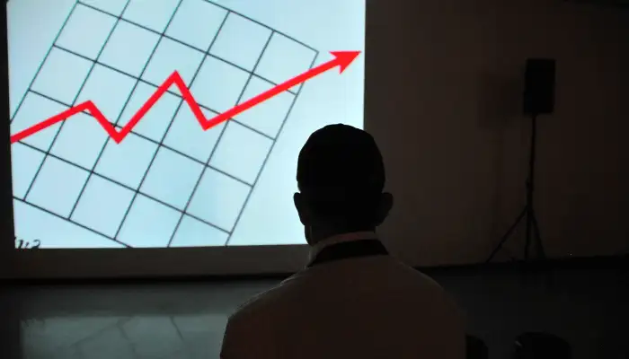 Man looking a projection of a chart trending upwards