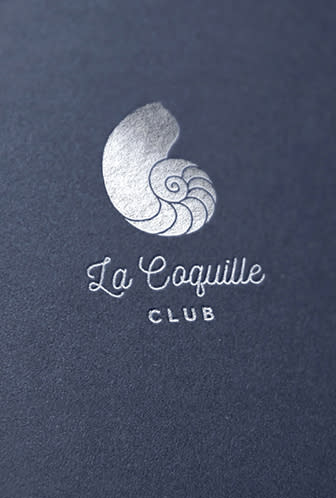 La Coquille Club logo printed on a blue surface.