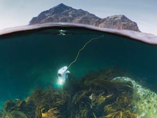 Blueye Pioneer diving with Stamsund mountains in the background