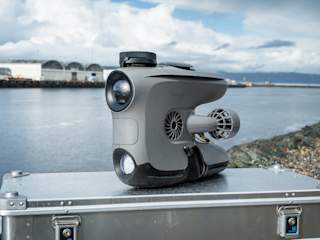 Blueye X3 with a GPS ontop a Zarges with the river running behind