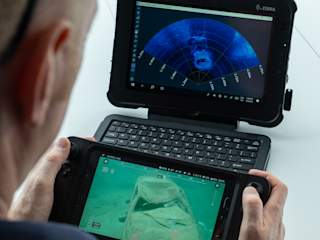 Operator using rugged controller and tablet watching Oculus sonar