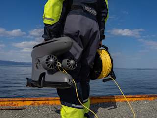 Holding the X3 ROV by the ocean