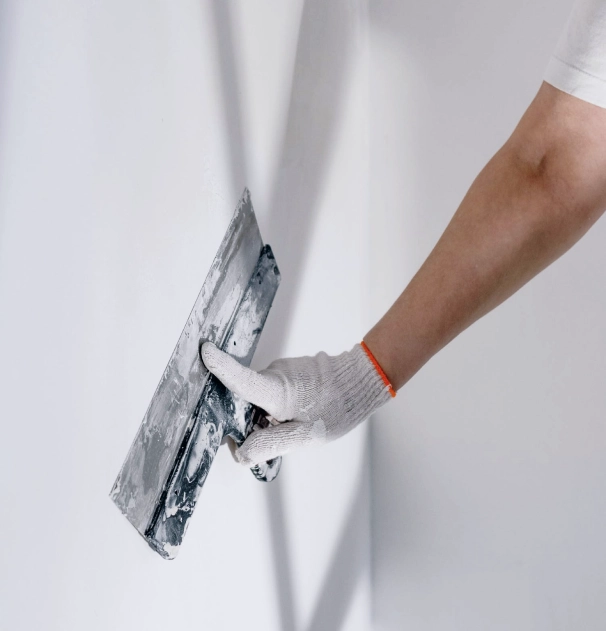 Person spackling a white wall