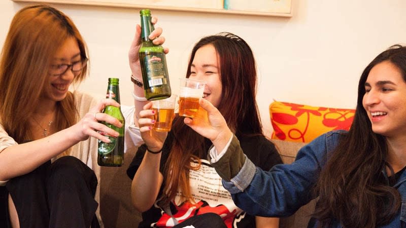 Group of three girls doing a toast with beer