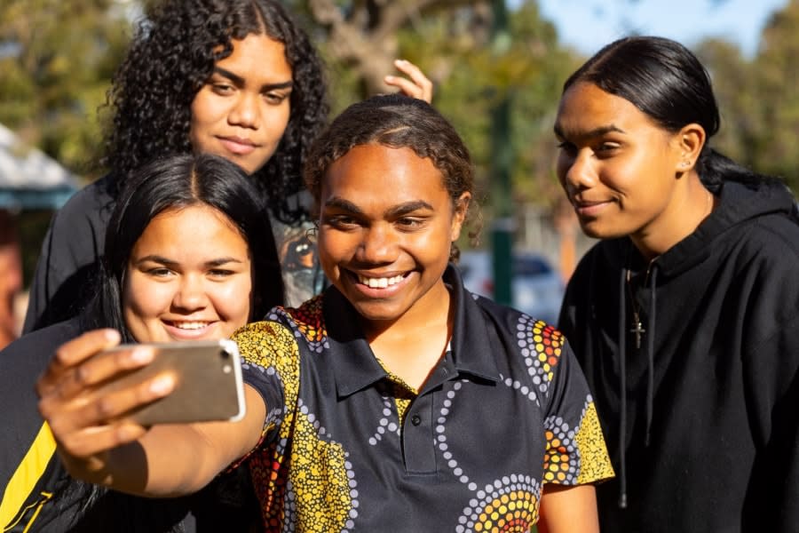 group of indigenous teen girls posing together for selfie outdoors