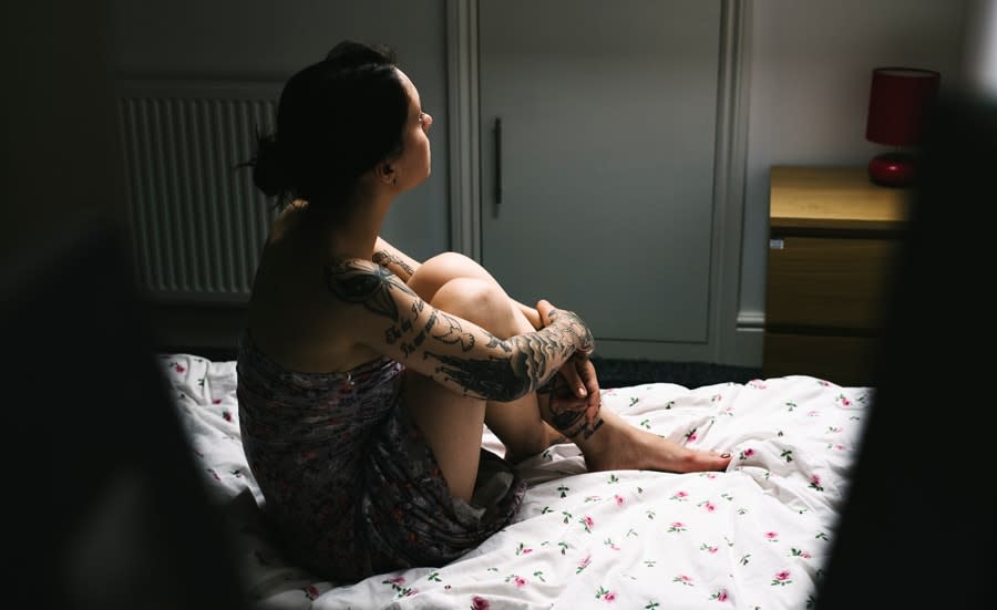 Girl with tattoos in bed