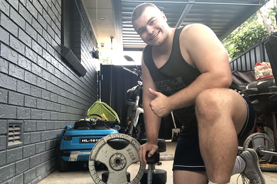 guy in workout clothes posing with gym equipment