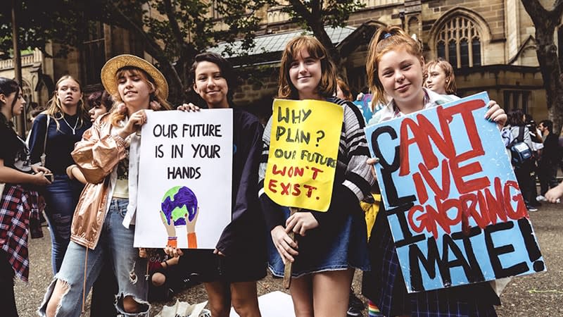 A group of four young people holding signs at the School Strike 4 Climate in Sydney. The signs read: ‘Our future is in your hands’, ‘Why plan? Our future won’t exist’ and ‘CLIMATE: Can’t Live Ignoring, MATE!’