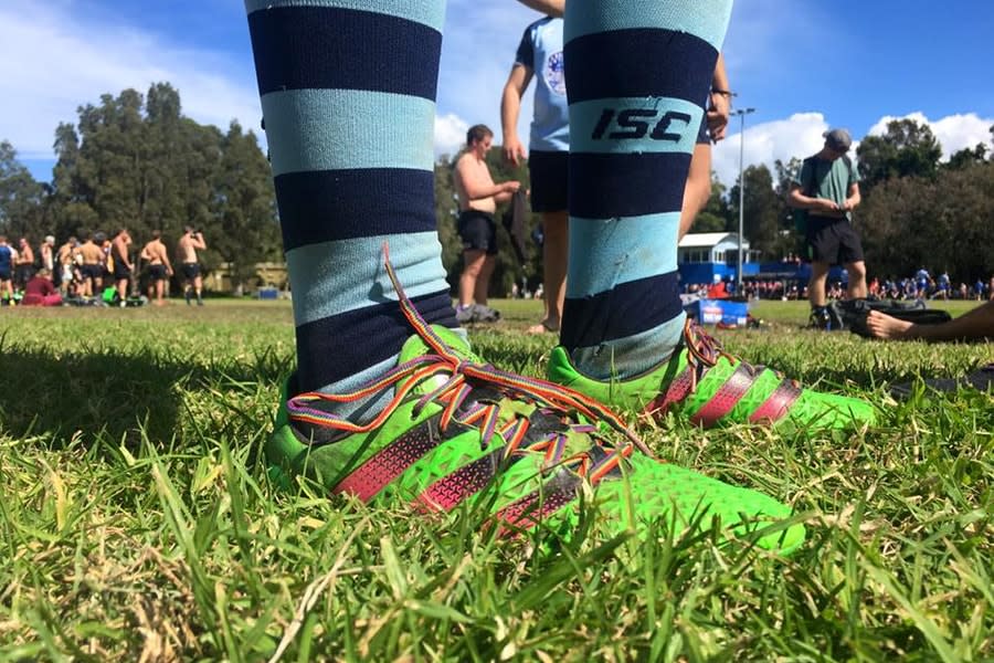 close up shot of rugby shoes standing in grass on sports field