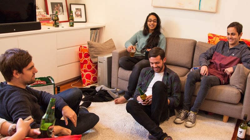 Group of four friends hanging with beer in lounge room