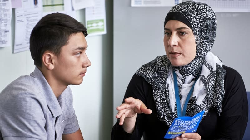 teacher talking to student in an office