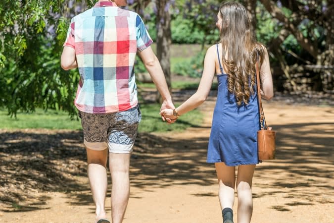Boy and girl holding hands in bushland