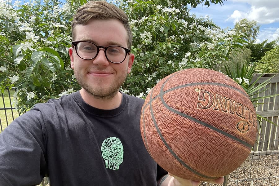 young guy wearing glasses holding basketball