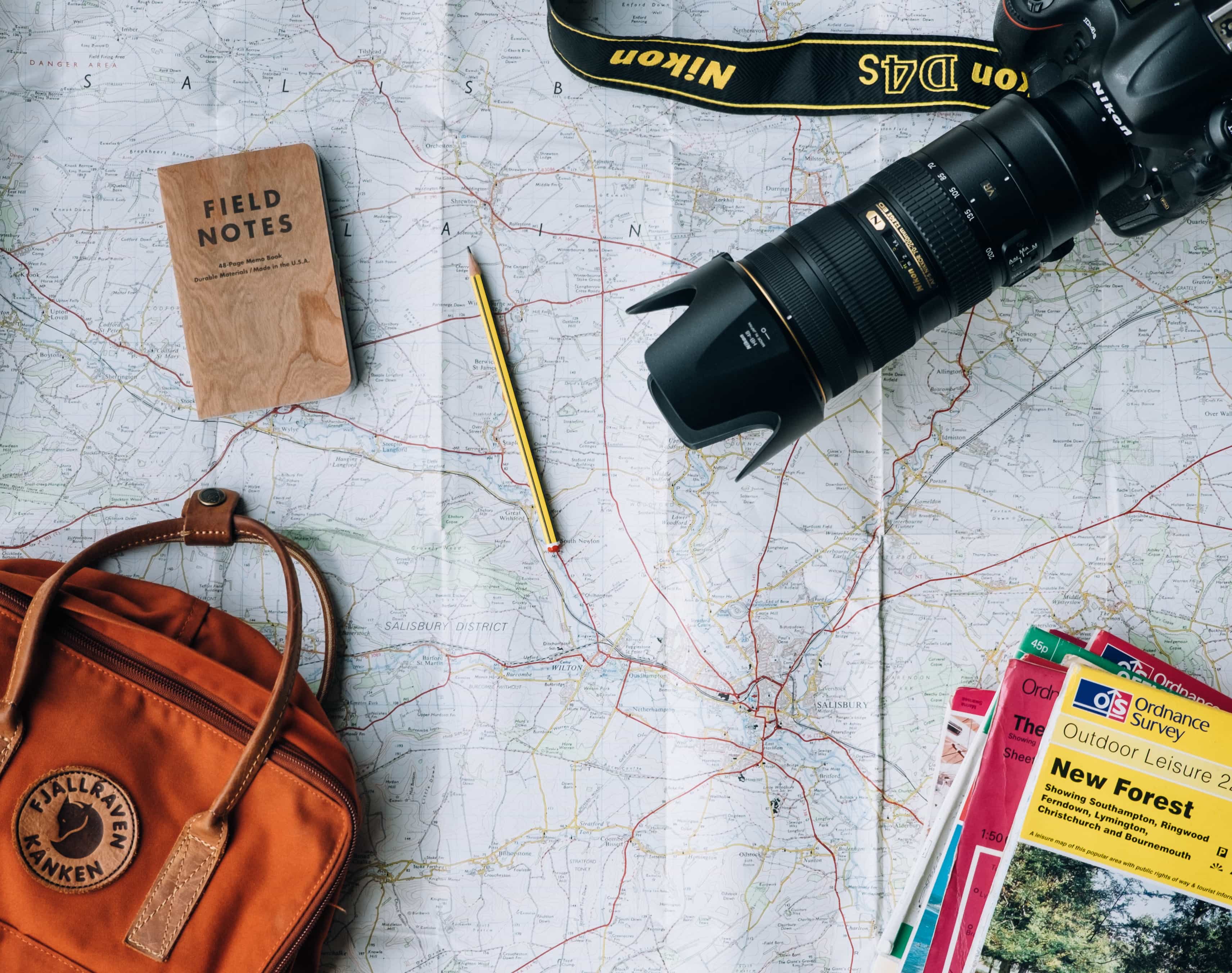 map with camera, bag and travel guides