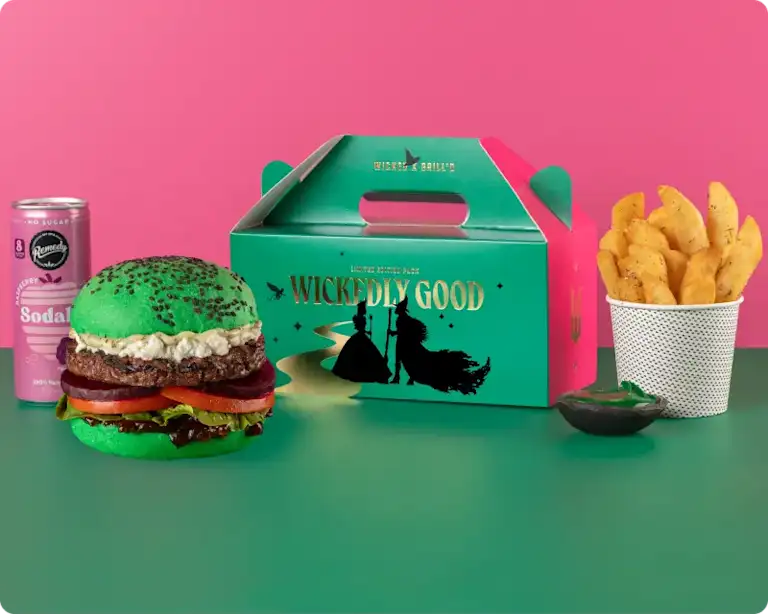 Grill'd Wicked kids pack, including a beef cheeseburger in a bright green bun, sodaly pink drink, snack chips, emerald mayo dip, and limited edition Wicked themed box.