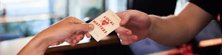 Local matters tokens being handed to a Grill'd guest
