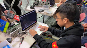 Image of team member programming robot.
