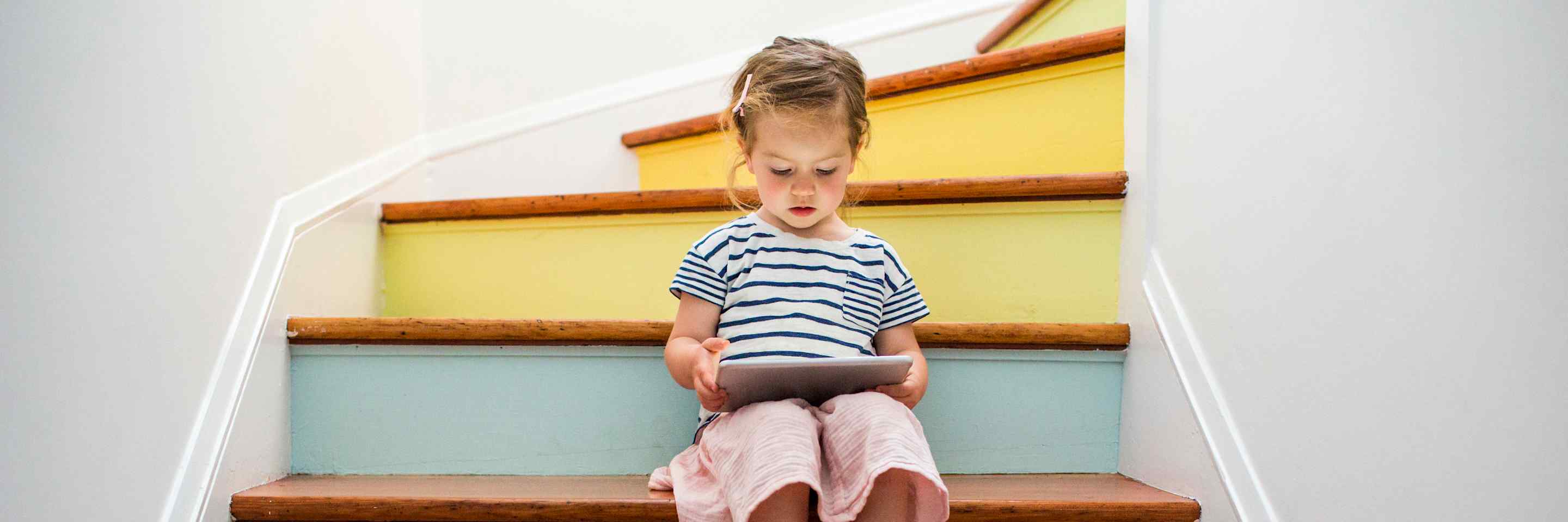 girl on the stairs looking at a tablet
