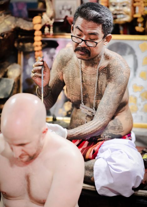 The sak yant tattoo is performed by the ajarn