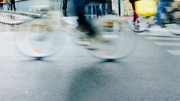 Cyclist riding quickly across pedestrian crossing