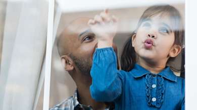 Father and daughter looking out of window