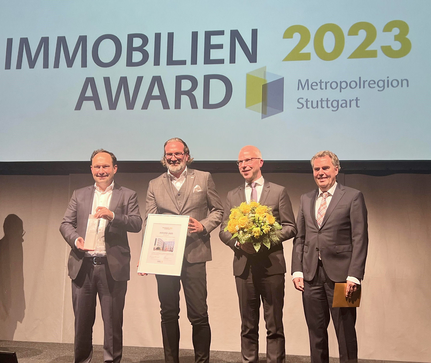 Repräsentanten von SRE und Züblin zeigen Urkunde und ihren Immobilien Award 2023