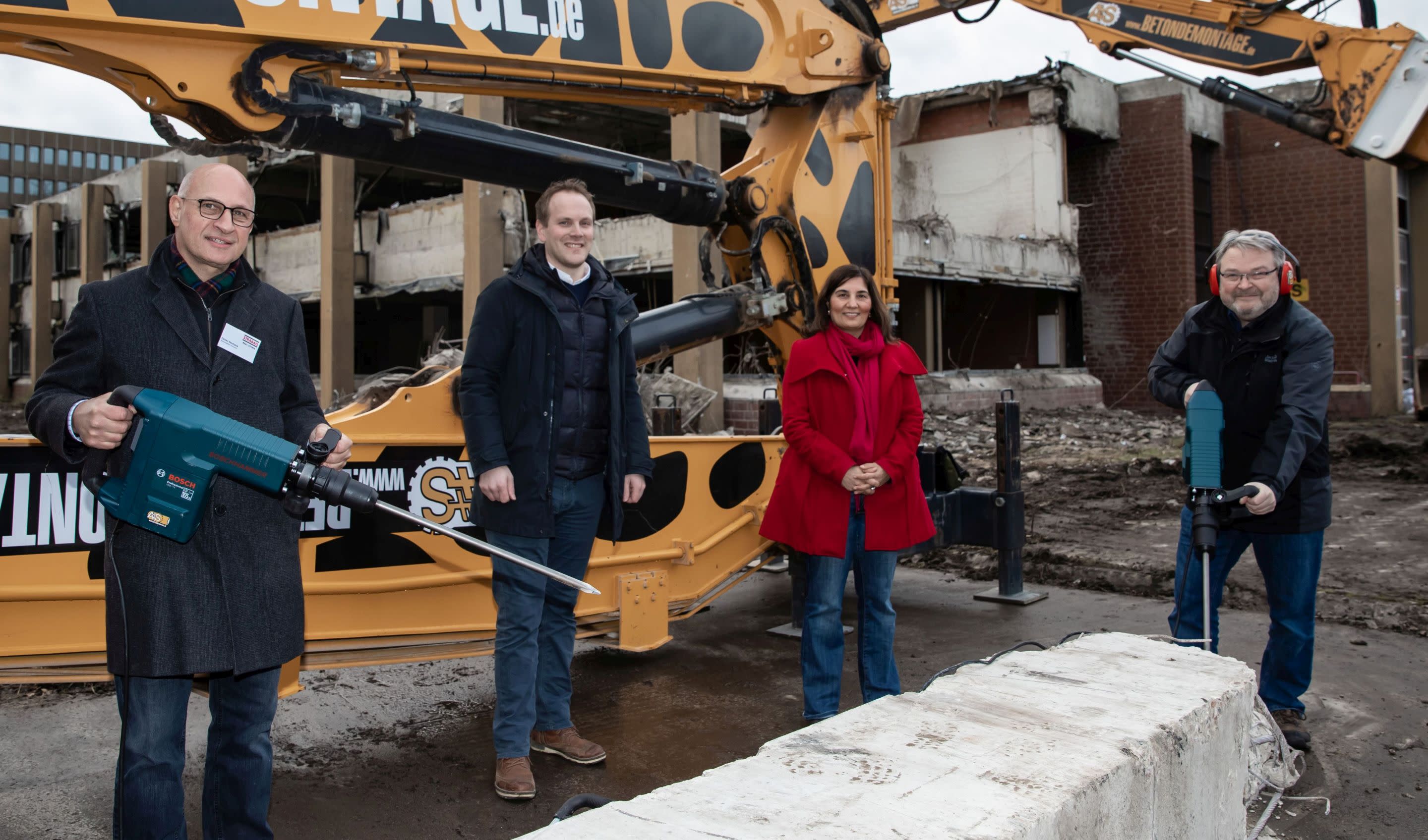 Vier Eventakteure an der Betonmauer mit Abrisshammer