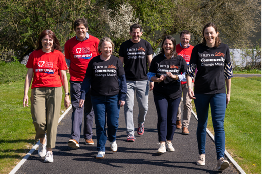 Seven people walking towards the camera with red and black T-shirts.