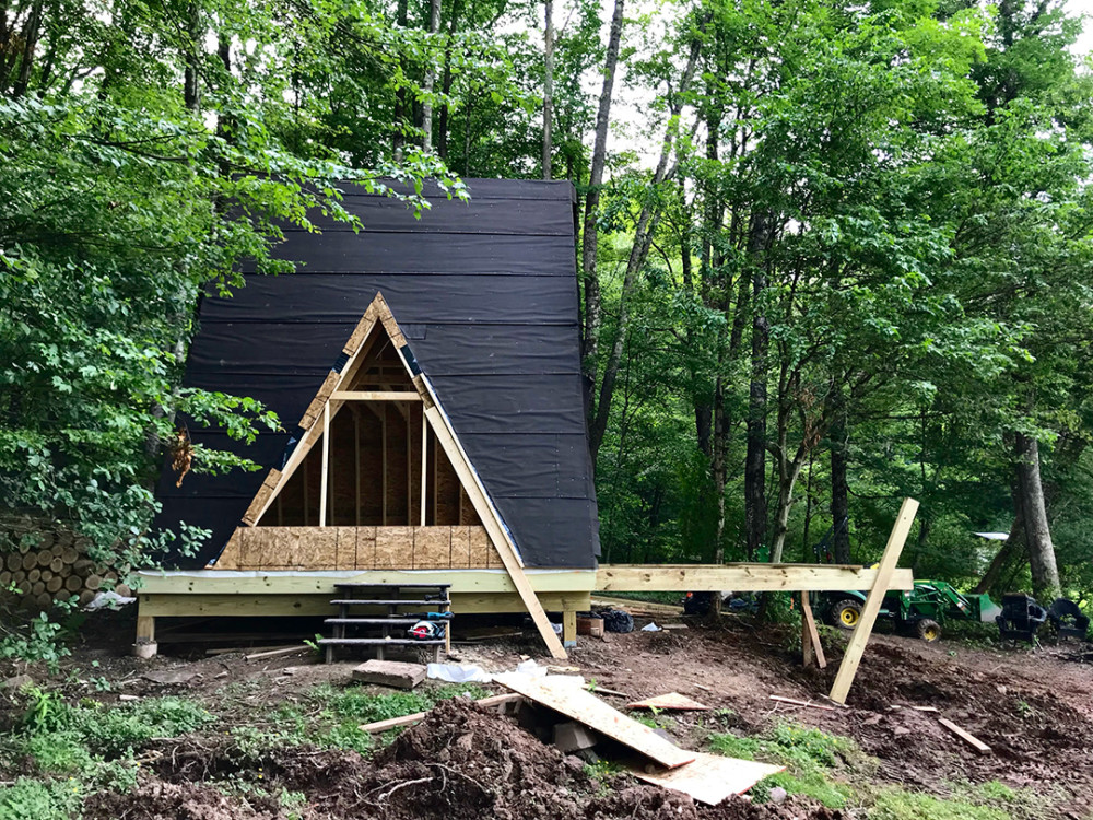Off grid heat in a not trending tiny house  Wood stove installation and  easy heat shield 