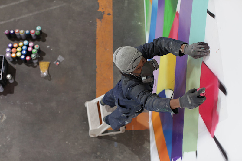 Street artist APEXER at work inside Timbuk2's Mission District HQ