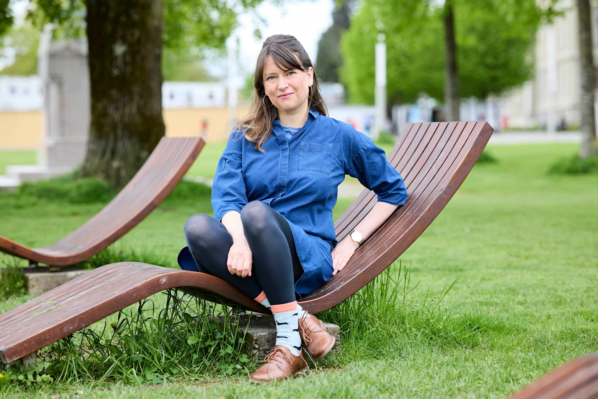 Giornalista nonostante la grave malattia Nicole Haas è seduta fuori su una panchina.