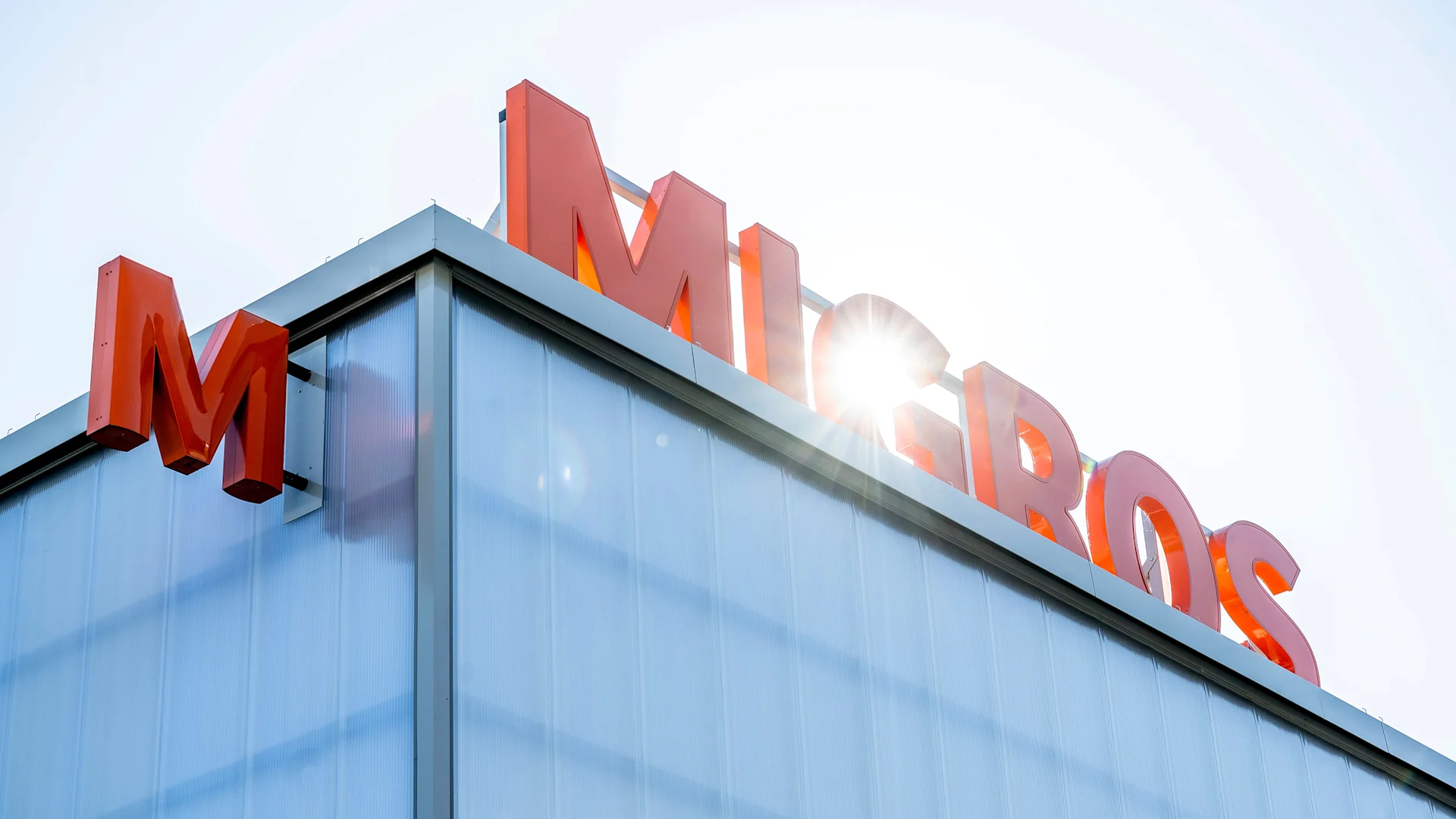 Die Migros ist 100 Jahre alt Migros Schriftzug auf einem Gebäudedach