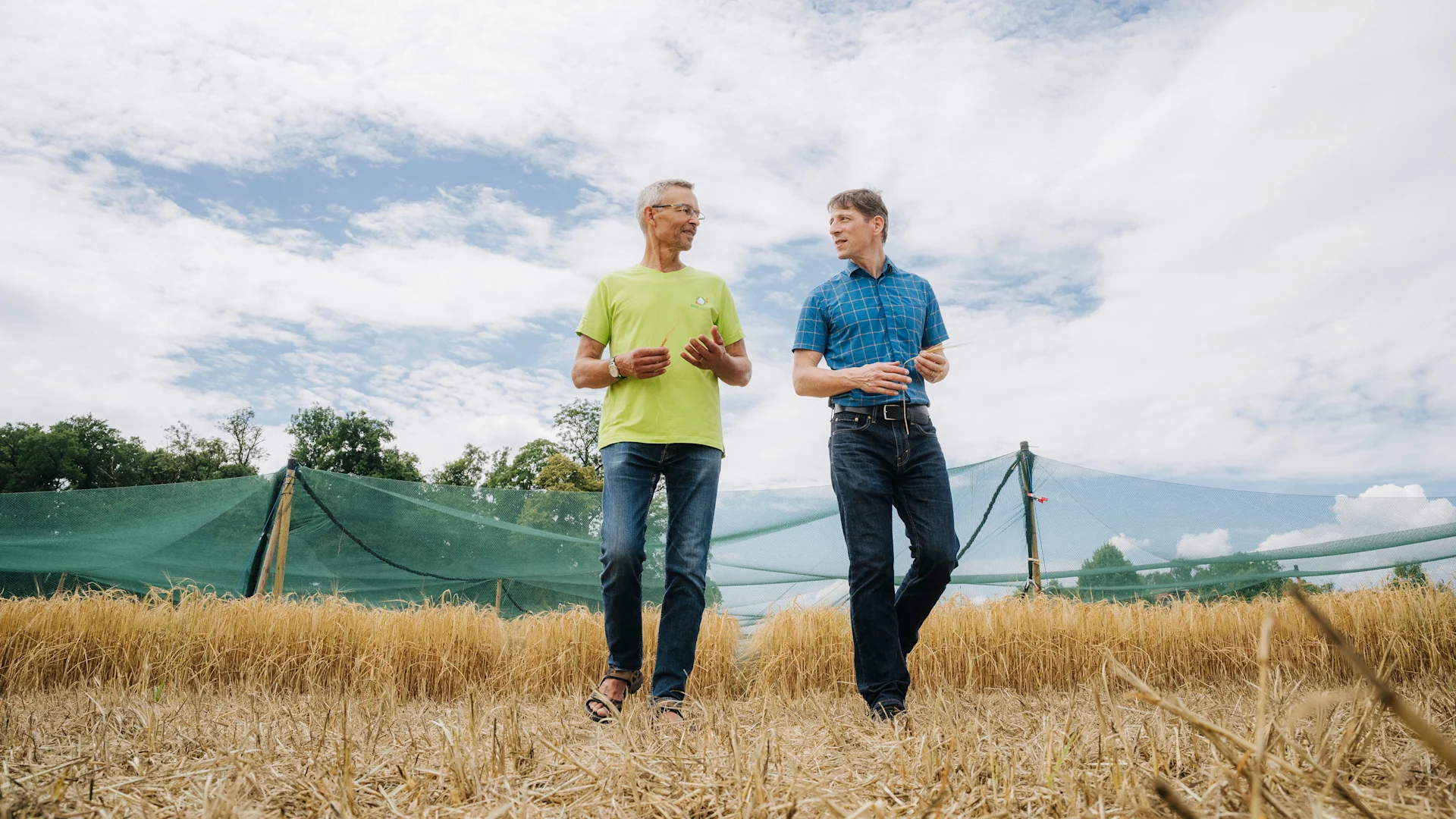 Le génie génétique dans l’agriculture Urs Brändli et Roland Peter discutent ensemble sur le champ d'essai d'Agroscope.