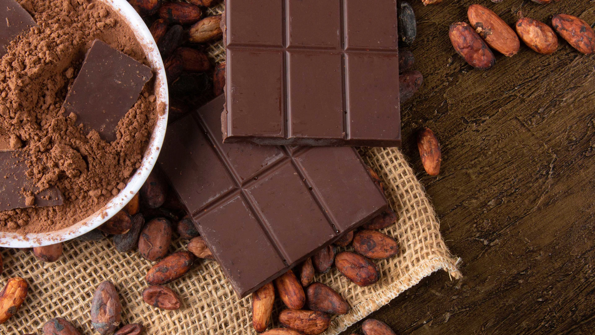 Perché il prezzo del cacao è alle stelle proprio adesso Il cacao in ogni sua forma: Fave di cacao, cacao in polvere e cioccolato fondente in blocchi.