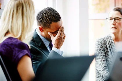 Businessman with head in hand during meeting