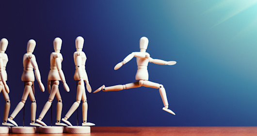 Puppet jumping away from a line of other puppets