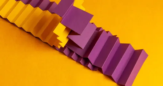 Two strips of paper folded into an accordion shape and intertwined
